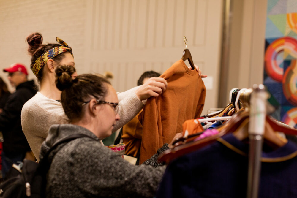 Two women looking through clothes on racks